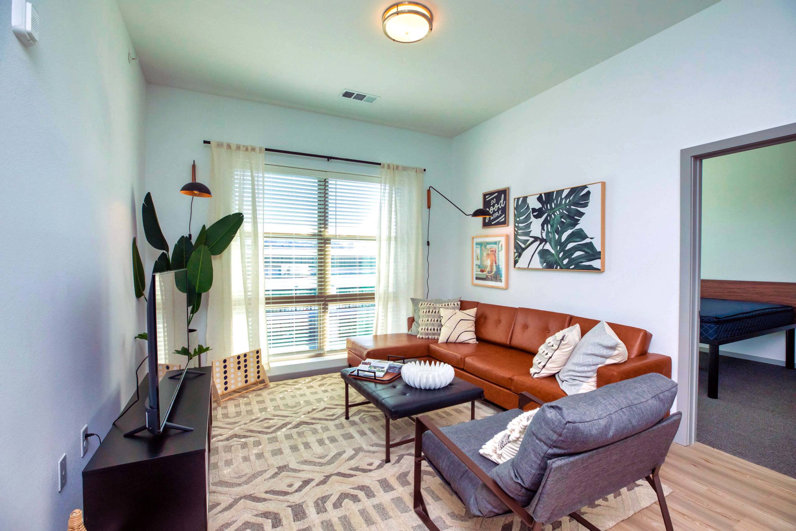 Living room with tv, couch, and chairs Lumen student apartments near the University of Alabama Birmingham living room with couch, tv, and chairs